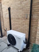 Air conditioning condenser unit installed outside a property